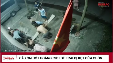 Cả xóm hốt hoảng cứu bé trai bị kẹt cửa cuốn