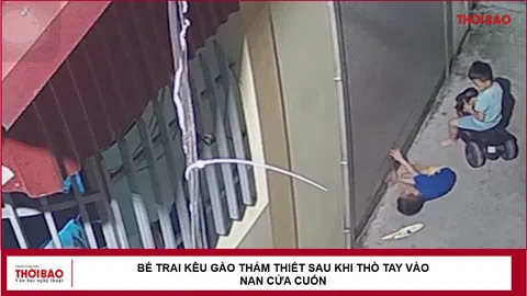 Bé trai kêu gào thảm thiết sau khi thò tay vào nan cửa cuốn